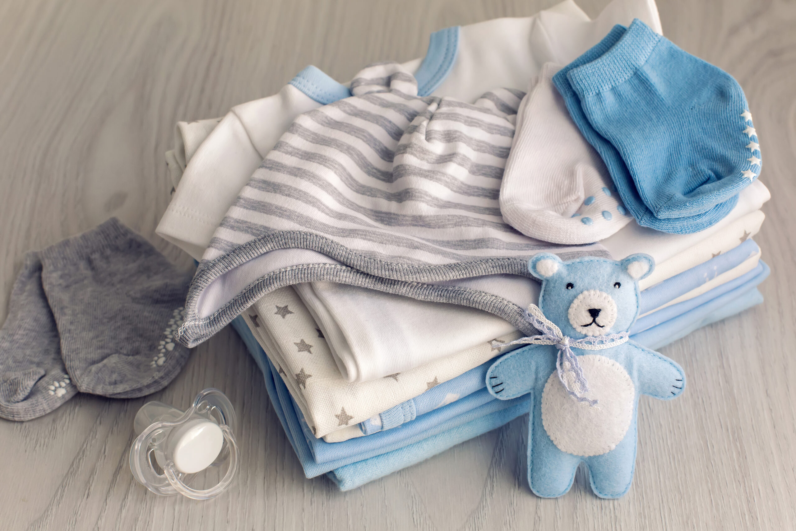 baby clothes with diapers are stacked